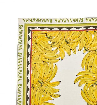 A rectangular tablecloth featuring a yellow banana print design with a cream background and a decorative border.