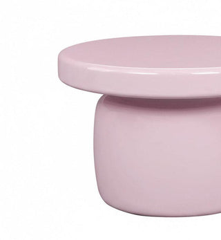A minimalist, glossy light pink side table with a round top and a cylindrical pedestal base, shown against a plain white background.